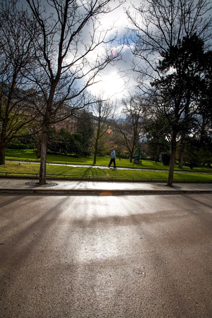 One of my favorite photographs shot from the hip of someone walking through the park. I like the bright, blown out portion of the image and the shadows of the trees coming toward the camera. Paris, France.